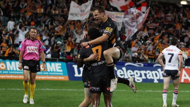 Tigers players celebrate Blake Ayshford's try against the Roosters on Saturday night.