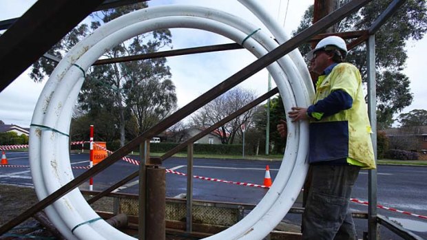 Workers lay pipes for fibre optic cables in Armidale.