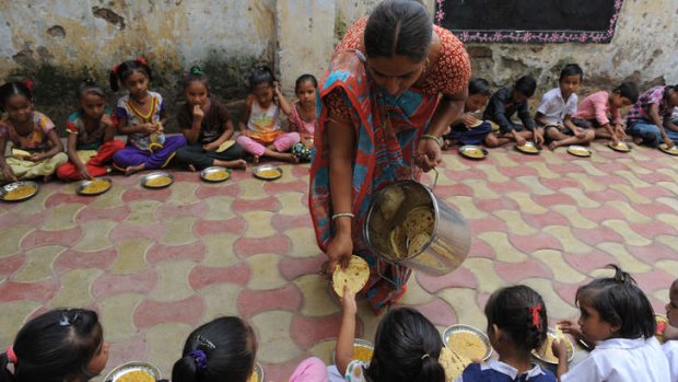 Indian schoolchildren at Jahangirpura Shala Number 2, which is run by the Ahmedabad Municipal Corporation, are served their free mid-day meal in Ahmedabad.