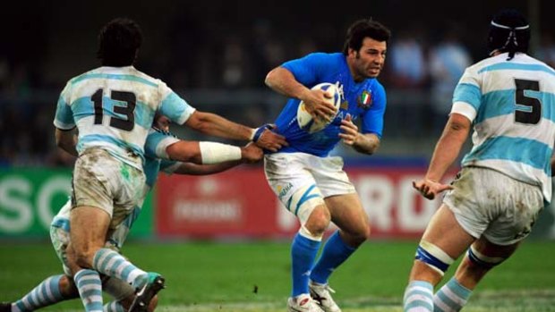 Former NRL player Craig Gower of Italy is tackled by Argentina's Gonzalo Tiesi.