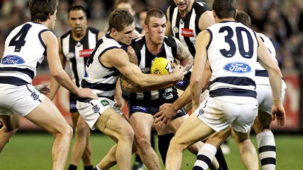 Stuck in the middle: Geelong’s Joel Selwood, Matthew Scarlett and Brad Ottens line up to tackle Dane Swan.