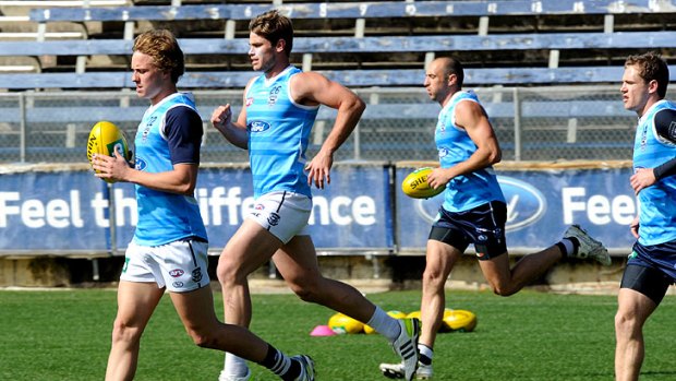 Mitch Duncan, Tom Hawkins and James Podsiadly at training yesterday.
