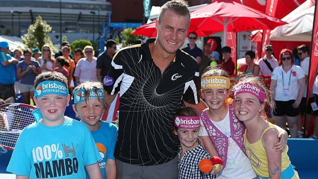 Lleyton Hewitt poses for photographs with children on day two of the Brisbane International.