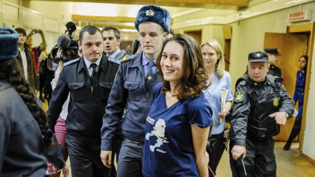 Greenpeace activist Alexandra Harris is escorted after a hearing at the Primorskiy Court in St Petersburg.