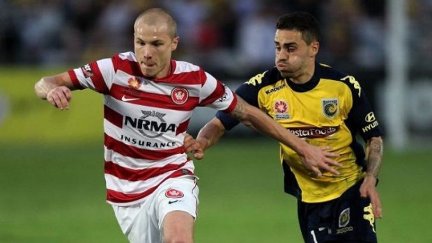 At a loss: Aaron Mooy of the Wanderers battles with Anthony Caceres of the Mariners.