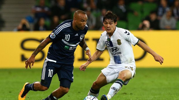 Archie Thompson attempts to get past a Jeonbuk defender.