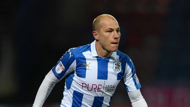 A crucial goal from Aaron Mooy has kept Huddersfield's promotion hopes alive.