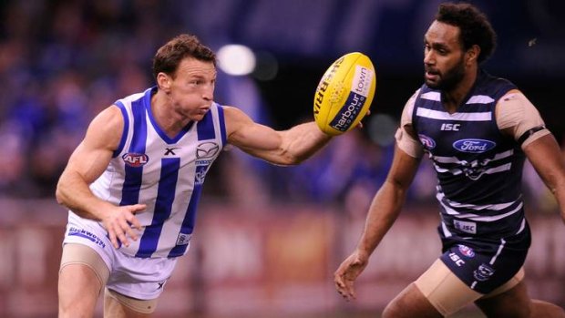 Handy performer: North Melbourne's Brent Harvey is confronted by Geelong's Travis Varcoe at Etihad Stadium on Friday night.