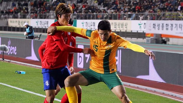 Go away: Socceroo Tom Rogic keeps South Korea's Hwang Seok-ho at arm's length.