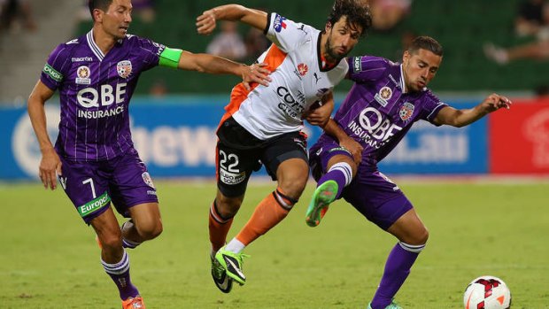 Thomas Broich of the Roar tussles with Jacob Burns and Adrian Zahra of the Glory.