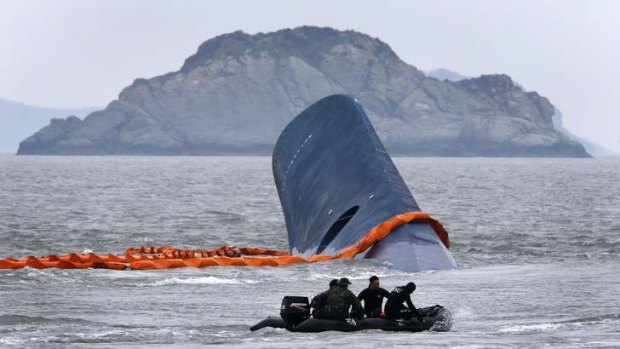 A salvage vessel passes the upturned South Korean ferry.