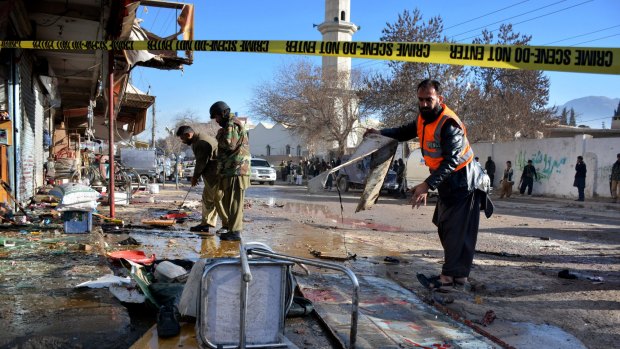 Pakistani police and rescue workers examine the site of suicide bombing that killed at least 15 in Quetta, Pakistan, last month. 