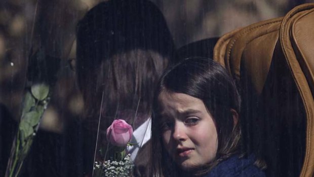 Paying tribute ... a girl holds a rose while waiting in a bus before visiting the scene of the accident.