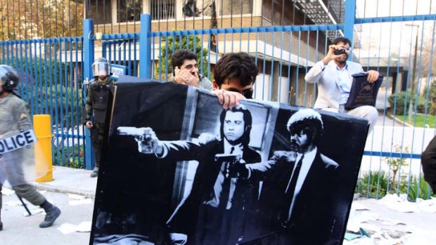 No fiction &#8230; a man holds up a poster from the movie Pulp Fiction following a violent demonstration at the British embassy in Iran's capital on Tuesday.