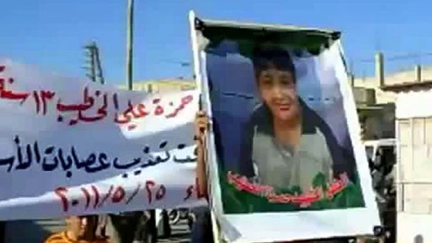 Tortured ... an image grab shows a Syrian man holding a picture of 13-year-old boy Hamza al-Khatib during his funeral on May 25 in the flashpoint region of Daraa.