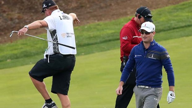 Zach Johnson smiles as caddie Damon Green celebrates after Johnson holed out from the drop zone on the 18th hole to force a play-off.