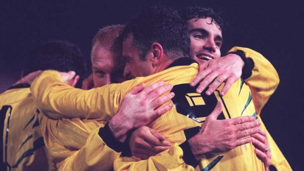 Fozzie bear hug &#8230; Craig Foster, right, and Robbie Slater, obscured at centre, celebrate together for the Socceroos in the late 1990s.