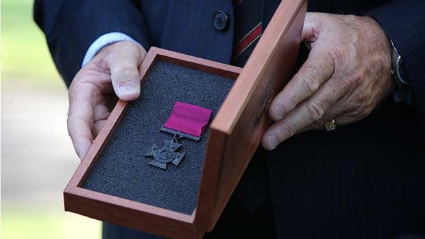 Doug Baird holds the Victoria Cross presented to him on behalf of his son.