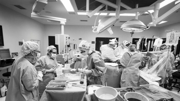 A Liver Transplant at The Austin Hospital, Melbourne. A wider image of the activity throughout the liver transplant surgery. Theatre staff are surrounding the table on the left which has the sterilised instruments, with the table on the right the already used equipment. Supplied pix from Andrew Chapman August 2016? picture are for use only when promoting?www.donatelife.gov.au?