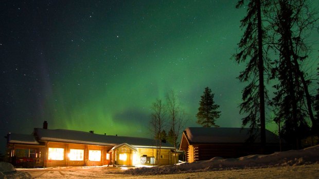 Aurora borealis, or Northern Lights, moving across the night sky at Winter basecamp Oulanka National Park.
