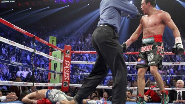 Shock ... Juan Manuel Marquez  is directed to a neutral corner after knocking out Manny Pacquiao.