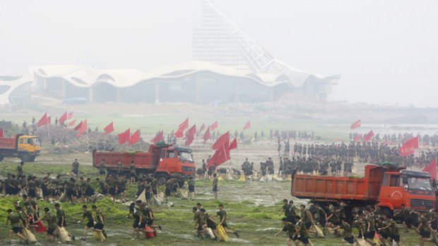 Chinese soldiers work to clear an algae bloom that covers one-third of the Olympic sailing venue.