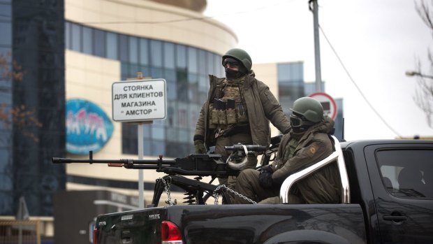 Tense times: Pro-Russian gunmen drive through central Donetsk on Monday.