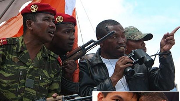 Soldiers watch Madagascar's opposition leader, Anchor Rajoelina, at a rally in Antananarivo where he claimed to have toppled the Government. Bottom: Mr Rajoelina with the man appointed prime minister, Roindefo Monja.