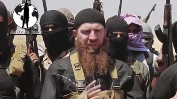 Islamic State of Iraq and the Levant leader Omar al-Shishani stands among a group of fighters as they declare the elimination of the border between Iraq and Syria. 