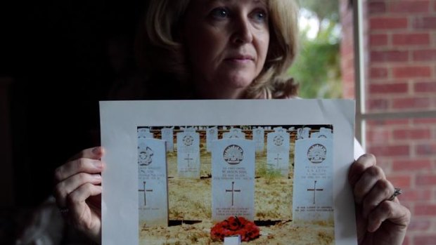 Robyn Burden with a photograph of the grave of her grandfather Walter Ayton.