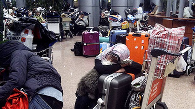 Stranded by the curfew, and prevented from entering Cairo, a woman is forced to sleep at Cairo Airport.