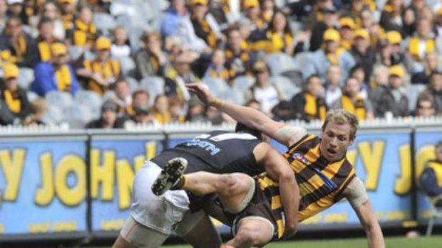 Port Adelaide's Alipate Carlile and Hawthorn's Michael Osborne come to grips at the MCG.