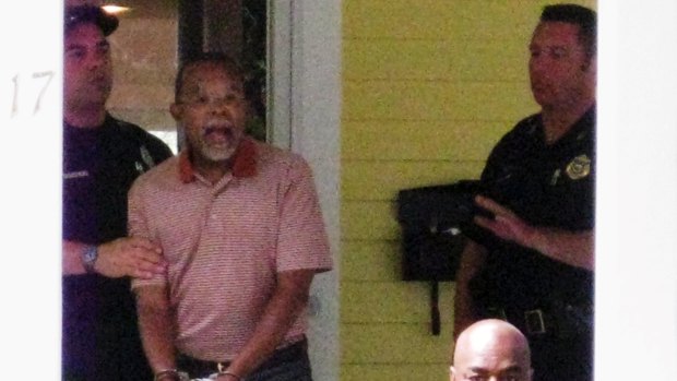 Under arrest in his own home ...  Professor Henry Louis Gates photographed by a neighbour being taken away.