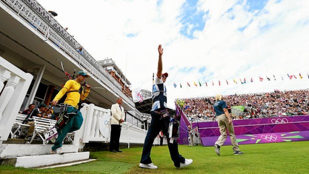 Alan Wills of Great Britain leads Taylor Worth of Australia out onto Lord's for their round of 32 archery elimination march at the London Olympics.