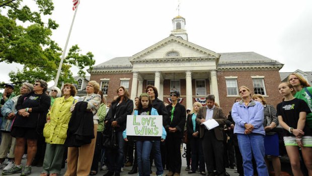 People gather during a ceremony on the six-month anniversary honoring the 20 children and six adults gunned down at Sandy Hook Elementary school on December 14, 2012 at Edmond Town Hall in Newtown, Connecticut, Friday, June 14, 2013.