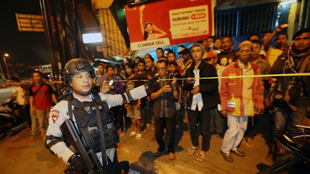 Police officers clear the scene after an explosion near a bus stop in the Kampung Melayu area of Jakarta.