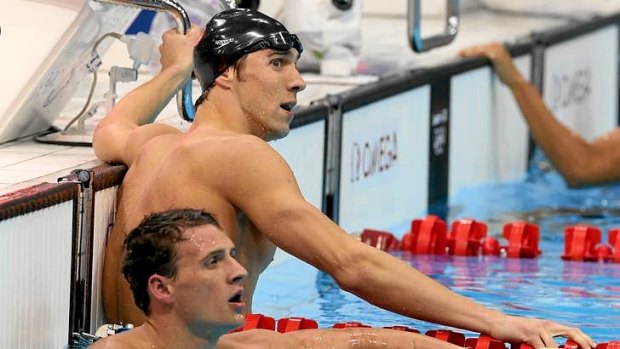 He's done it again: Michael Phelps (in cap) looks back at the time board after beating US teammate Ryan Lochte (foreground) to win the 200m individual medley gold medal.