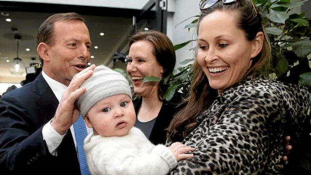 Tony Abbott and Liberal MP Kelly O'Dwyer meet with Amelia Taylor and 5-month-old Thomas during an election campaign visit to a Melbourne cafe to promote the paid parental leave scheme.