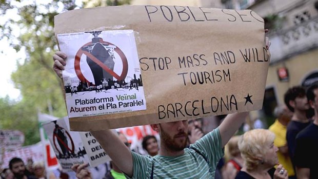 A resident of La Barceloneta holds a placard during a demonstration against "drunken tourism" in their neighbourhood in Barcelona.