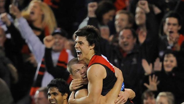 Essendon's Angus Monfries and Jake Melksham celebrate a final goal last night in their surprise win over the Cats.