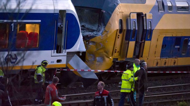 Officials inspect the wreckage of two trains which collided between stations in Amsterdam.