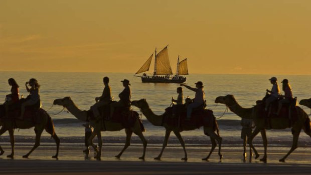 Sunset: Home-going camel trekkers pass a pearl lugger in Broome.