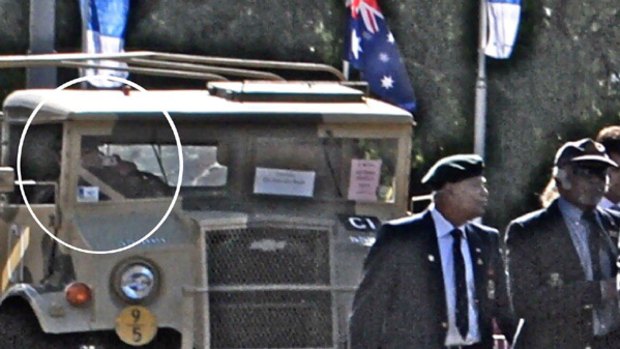 When magnified, the photos show the Anzac parade driver using both hands to use a camera to take photos through the truck windscreen.