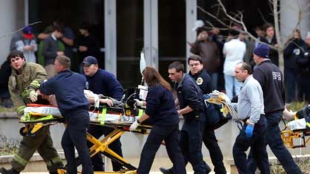 Shooting victims are taken from the Shelby Center on the campus of the University of Alabama to an ambulance after multiple people were shot in Huntsville