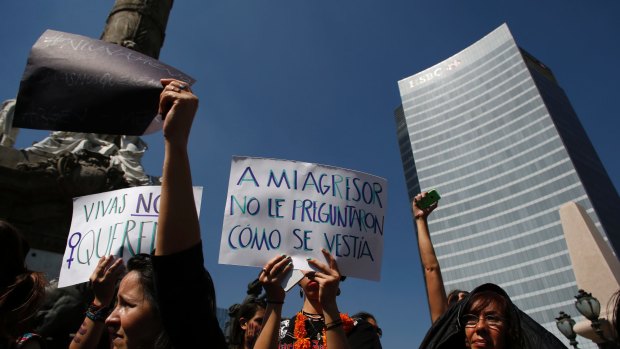 A protester holds a sign that reads in Spanish: "They didn't ask my aggressor how he was dressed," during a demonstration to protest violence against women in Mexico City on Wednesday. Women across Latin America participated in protests in response to the rape and murder of a teenage girl on October 8 in Argentina.