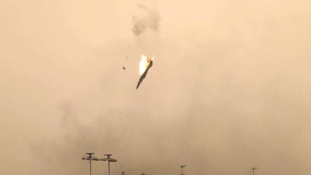 A parachute is ejected from a Libyan jet bomber as it crashes after being hit over Benghazi today as Libya's rebel stronghold came under attack.