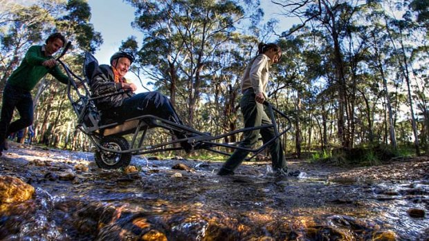 Bush wheeling: Parks Victoria provides the power source (Amy Anderson and David Petty) and Dave Stratton helps navigate the all-terrain wheelchair through the bush.