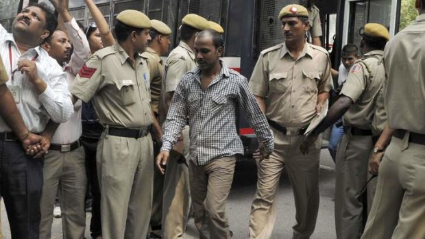 Mukesh Singh (centre), one of the four men who were sentenced to death for the rape and murder of a young woman on a bus last December, is escorted by police outside a court in New Delhi.
