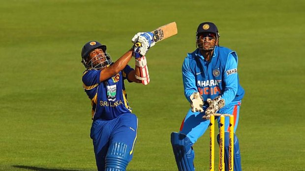 Tillakaratne Dilshan hits a boundary during his unbeaten 160 as India's wicketkeeper M.S. Dhoni looks on.