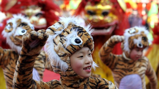 Children dressed in tiger costumes perform during the opening of Longtan Temple Fair on the Lunar New Year Eve in Beijing.